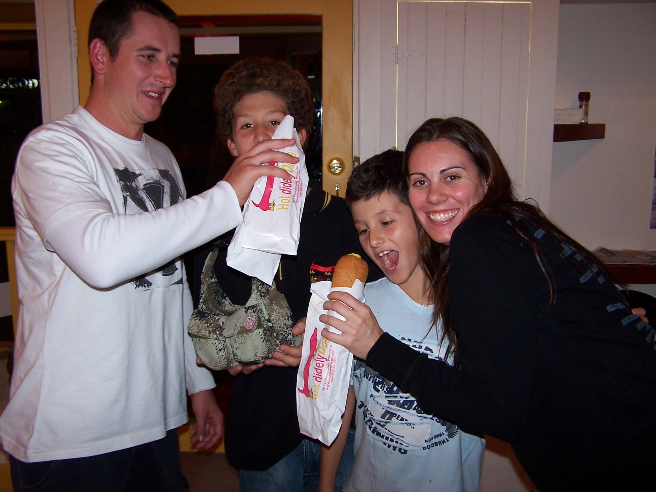 Happy family enjoying Hot Didely Dogs branded hot dogs together